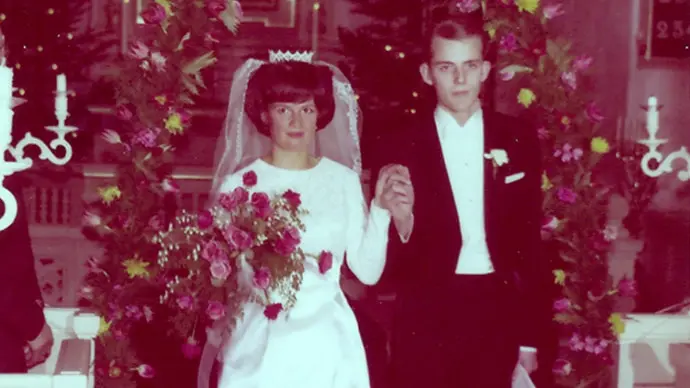 Bröllopsfoto från 1960-talet. Brudparet står hand i hand vi altargången. 