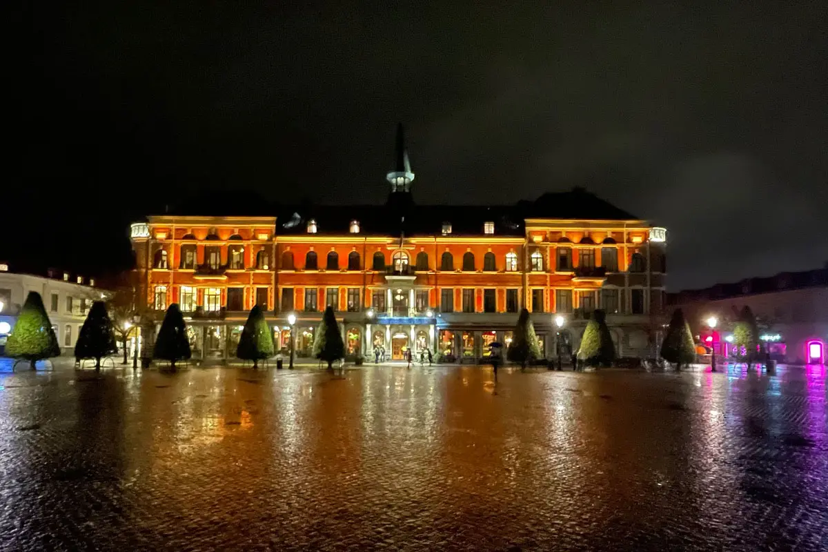 Varbergs Stadshotell upplyst med orange fasadbelysning. 