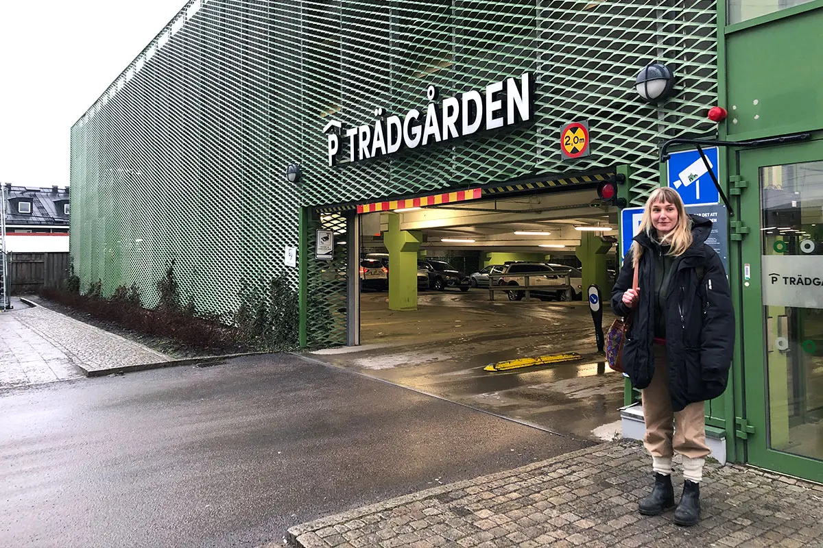 Konstnären Ebba Chambert står utanför parkeringshuset Trädgården. Det är gråmulet väder.