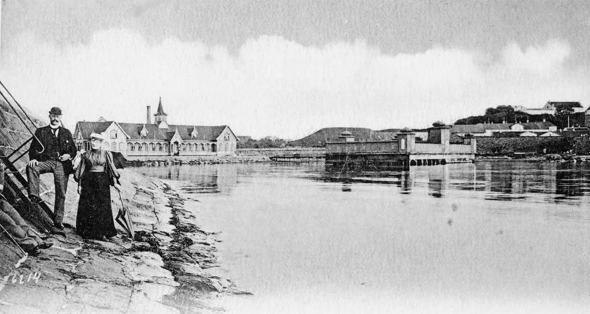 Fotot från år 1885 är unikt med två kallbadhus bredvid varandra. Foto i svartvitt. Utanför barnens badstrand tronar två kallbadhus bredvid varandra. 